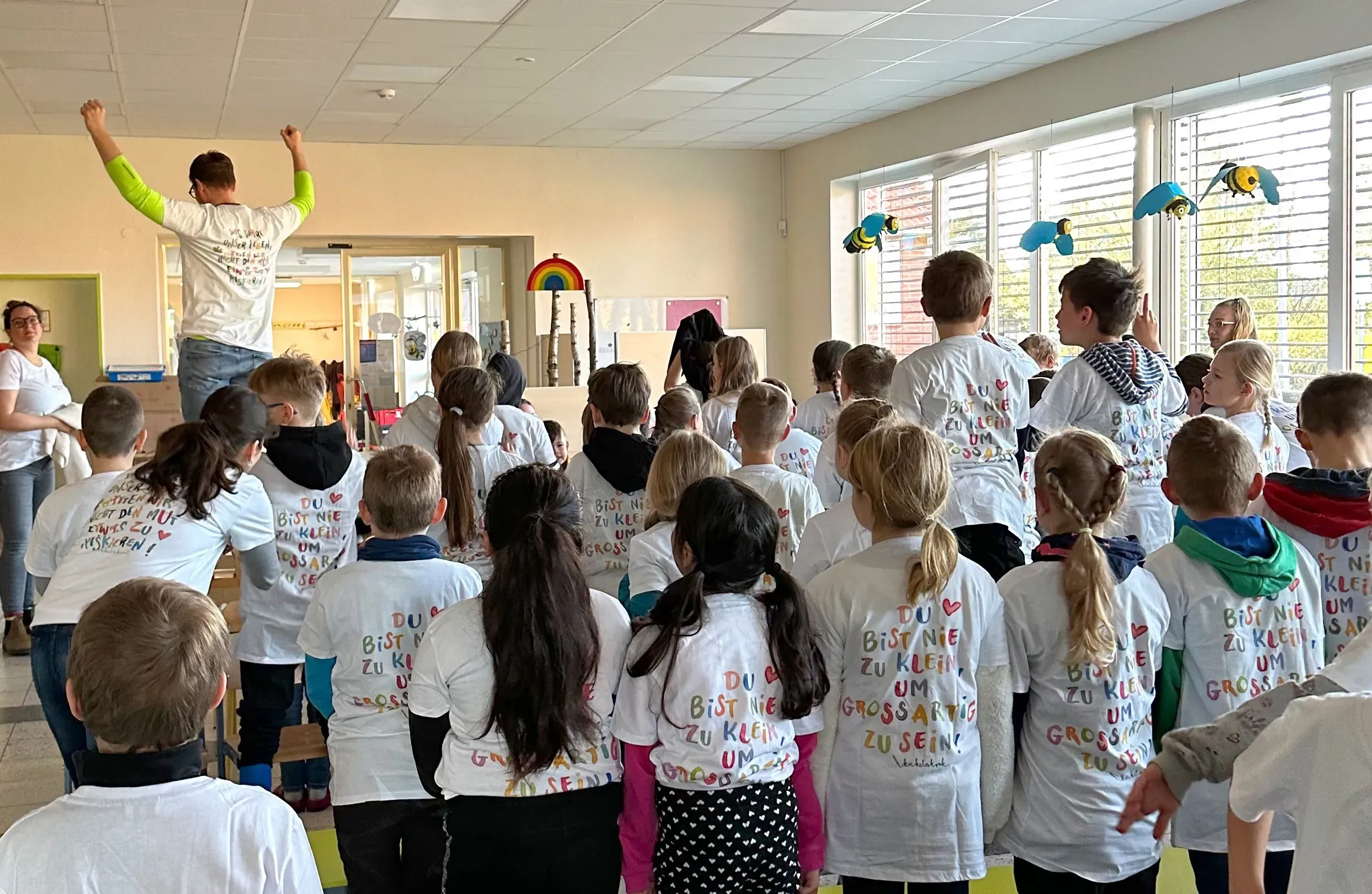 Eine Gruppe Kinder mit Motto-T-Shirts im Klassenzimmer