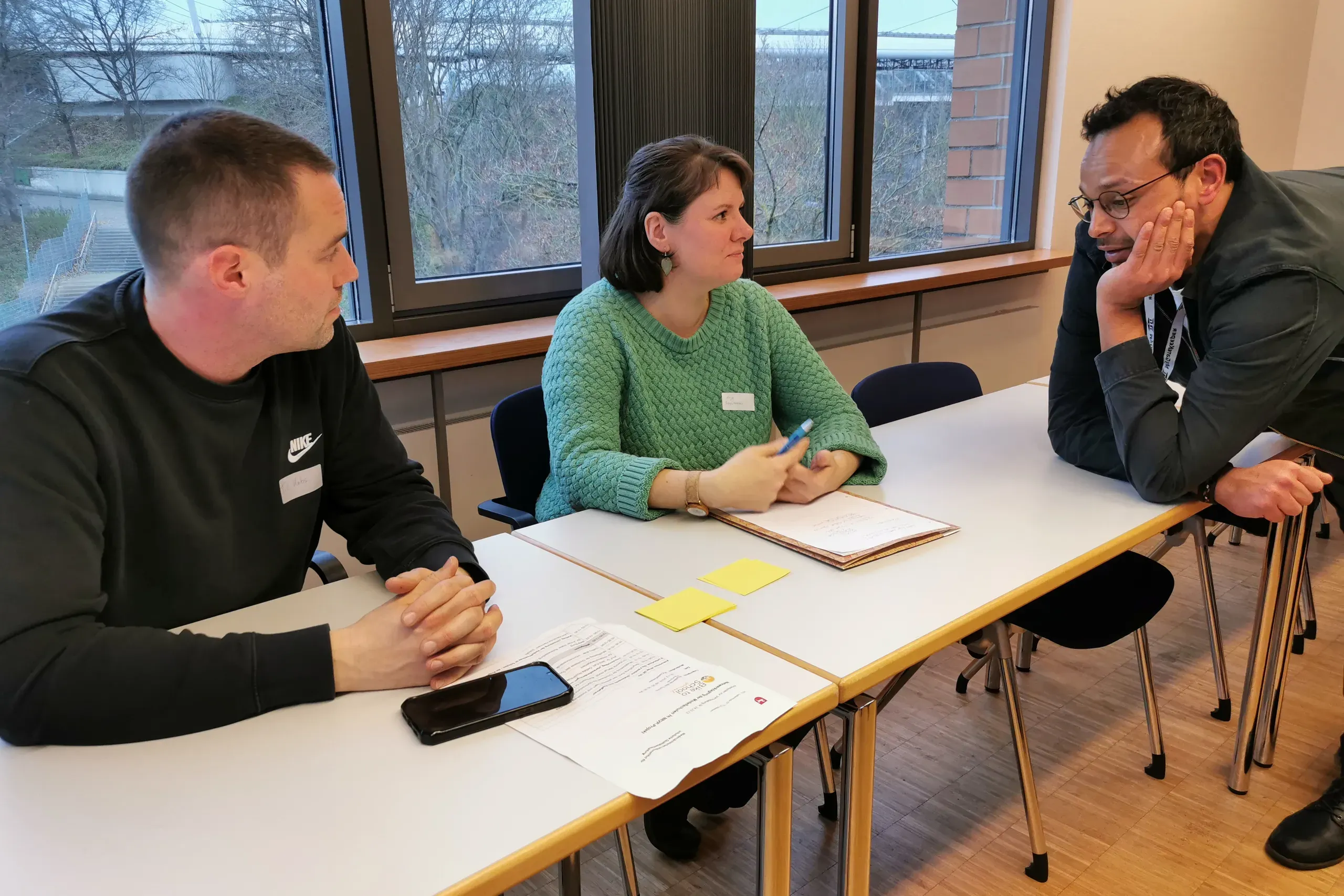 David Salim spricht mit zwei Teilnehmenden.